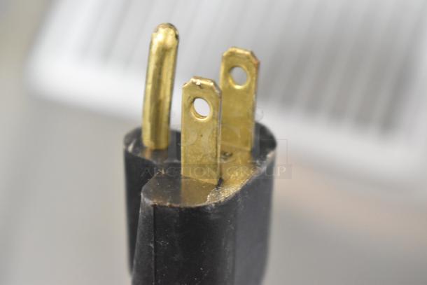 Close-up of a three-prong plug for a Traulsen AHT 2-32 WUT stainless steel commercial cooler. 115 volts, 1 phase.