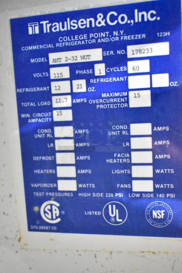 Traulsen AHT 2-32 WUT stainless steel commercial cooler, 2-door with racks, 115V, 1 phase. Visible specs: model, voltage, refrigerant.
