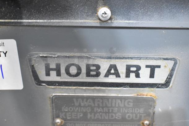 Hobart HF 270 dough mixer label, showing model and brand. Contains safety warning about moving parts inside.