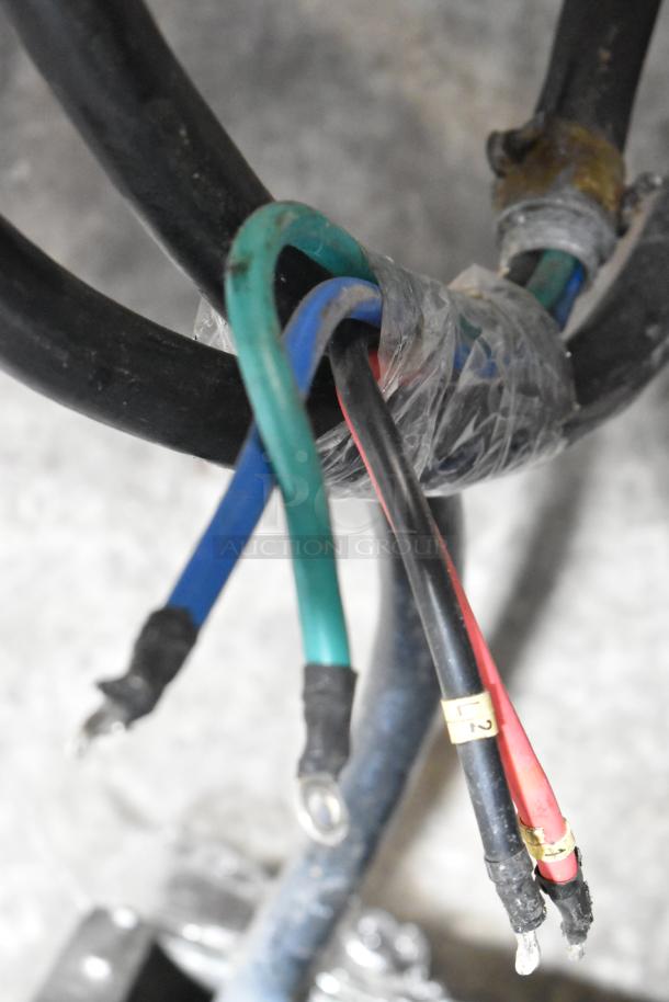 Electrical wires wrapped with tape, featuring red, blue, and green cables. Ends have metal loops for connections.