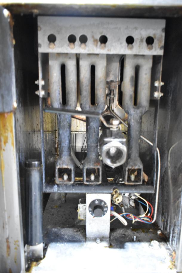 Cookrite stainless steel commercial gas-powered deep fat fryer, internal view showing gas burners, moderate wear visible.