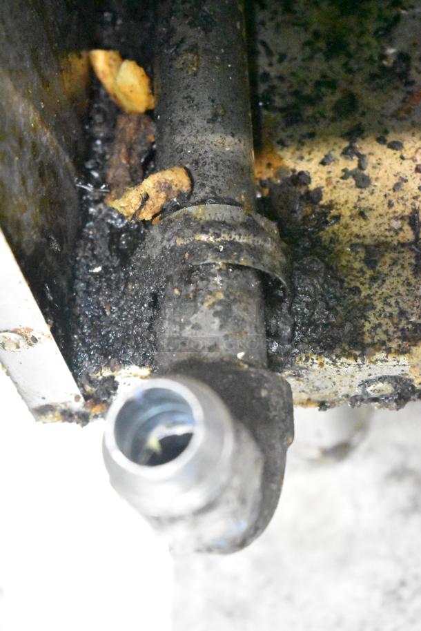 Tri-Star gas fryer showing interior oil buildup, pipe detail; requires cleaning. Comes with two metal fry baskets.