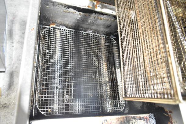 Tri-Star stainless steel commercial gas deep fat fryer with two metal fry baskets, showing oil level markings. Used condition.