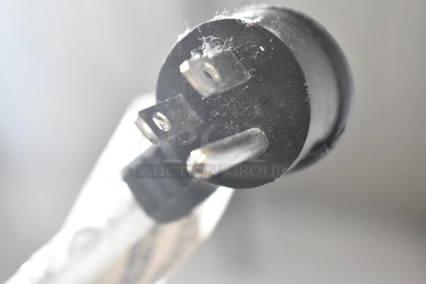 Close-up of a three-prong plug from a Crane 5800-4 vending machine, 115 volts, 1 phase.