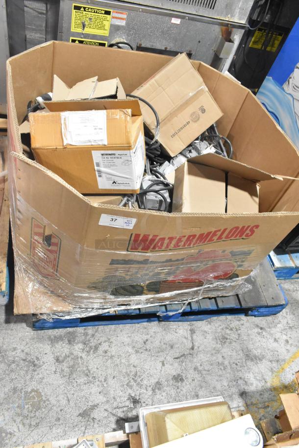 Pallet of assorted items including shoe covers, wires, and Wiremold outlet box. Items in a large cardboard box labeled "Watermelons."