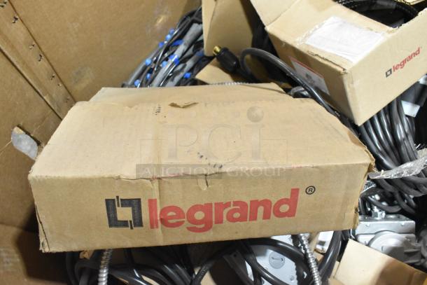 Pallet lot with Legrand boxes, wires, and outlet boxes. Includes Critical Cover AquaTank Shoe Covers. Visible brand logo. Mixed items in worn boxes.