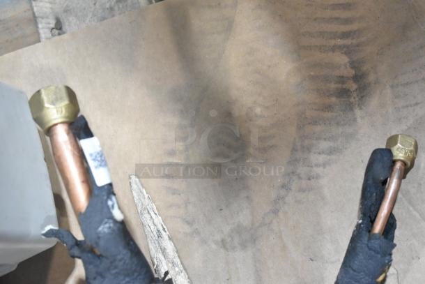 Copper connectors on a 2025 Garvee SAC18-2-S19 air conditioning unit. Includes visible labeling and insulation.