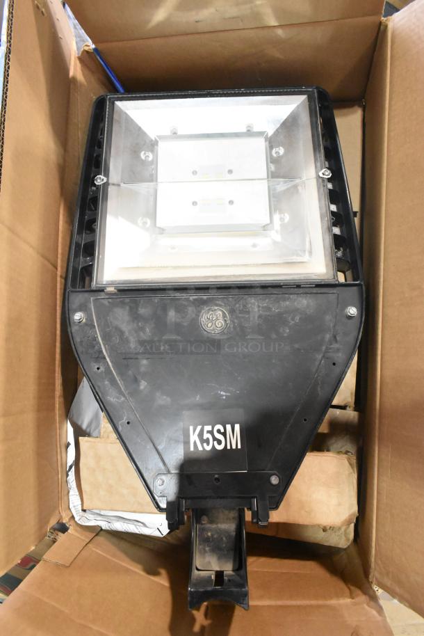 Pallet lot with outdoor light fixture, marked "K5SM," in a cardboard box. Includes GE branding, good condition.