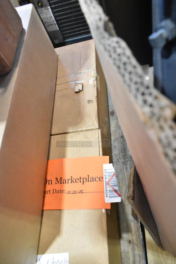 Boxes containing General Electric light fixtures and Current Evolve LED series, auction label with start date 10-20-23.