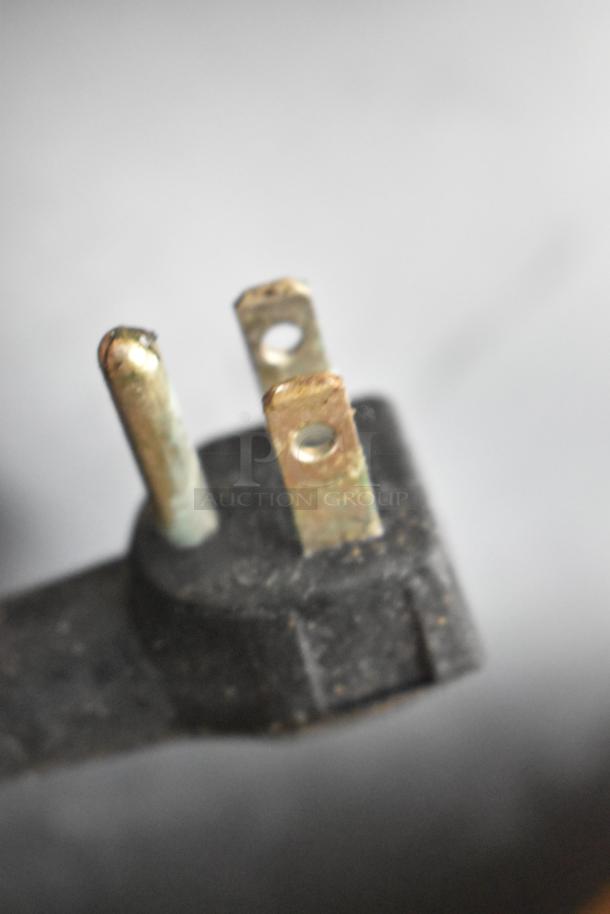Close-up of a three-pronged electrical plug for an Euhomy RF-H Mini Cooler, showing signs of use and slight wear.