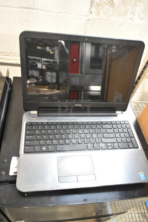 Dell Inspiron 15R-5537 laptop with visible wear, showing keyboard and touchpad. Comes with charger, Intel inside label.