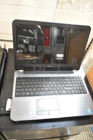 Dell Inspiron 15R-5537 laptop with visible wear, showing keyboard and touchpad. Comes with charger, Intel inside label.