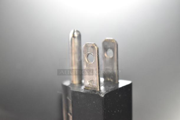 The image shows a close-up of an electrical plug prong.