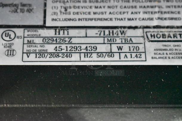 2024 Hobart HTi-7LH4W metal countertop scale with label printer, missing plate. Does not power on. Model and serial numbers visible.