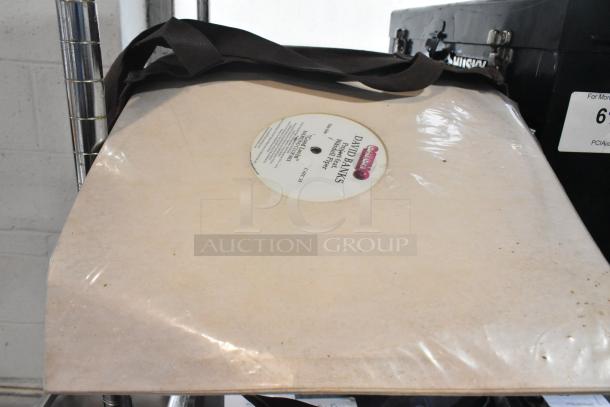 Alt text: Husky black metal toolbox with tools, a vinyl record in a clear sleeve, and a black tent strap.