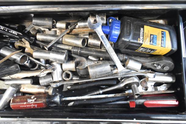 Husky black metal toolbox with assorted tools, including wrenches and sockets. Visible Bostitch label on container. Used condition.