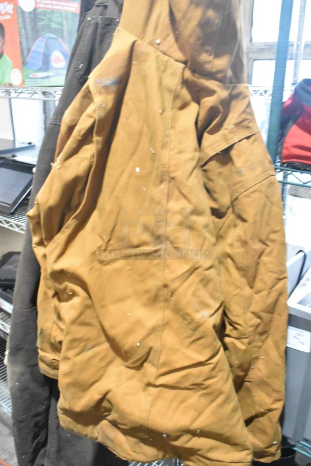 Auction lot featuring Berne Apparel and Carhartt overalls, Ryobi saw, and ropes. Items show signs of wear.