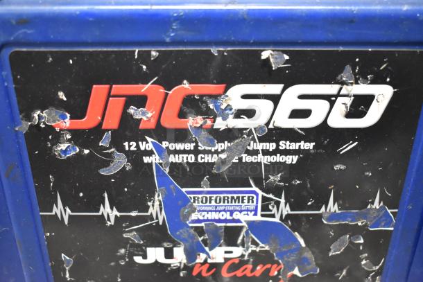 JNC660 Jump Starter with visible wear and scratches. Features 12V power supply and auto charge technology.