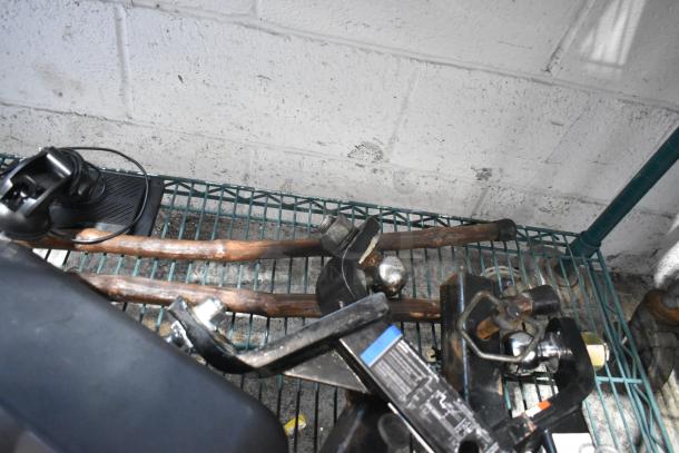 Tiered lot with various items including boots, a speaker, and a hitch. Items are on a metal shelf in used condition.