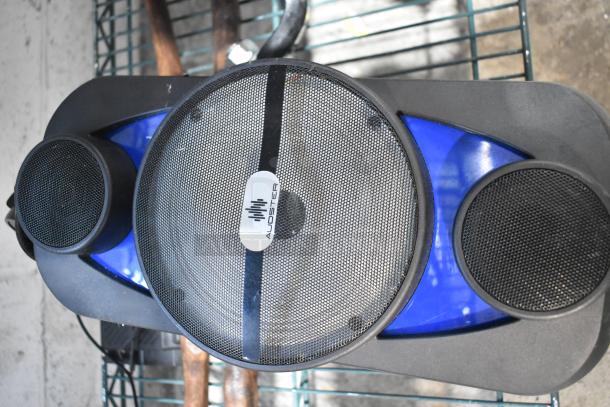 Audster speaker with black grille, blue accents, and visible logo. Appears in used condition, part of an auction lot.
