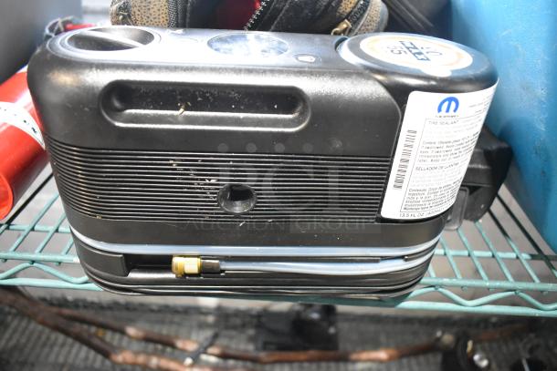 Various items on a shelf, including a portable DVD player, DVDs, markers, tools, and an Amerex fire extinguisher.