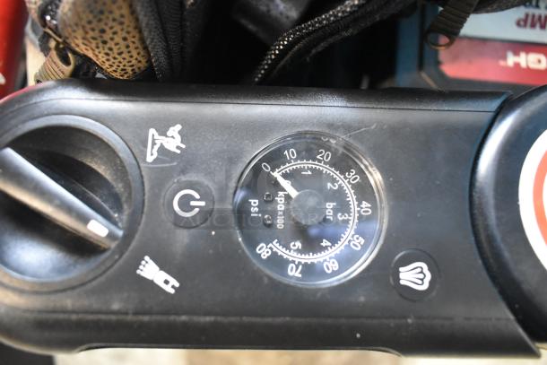Close-up of a gauge on the ALL ONE MONEY auction tier lot, indicating pressure in psi and bar. Includes portable DVD player, DVDs, markers, tools, and an Amerex fire extinguisher.