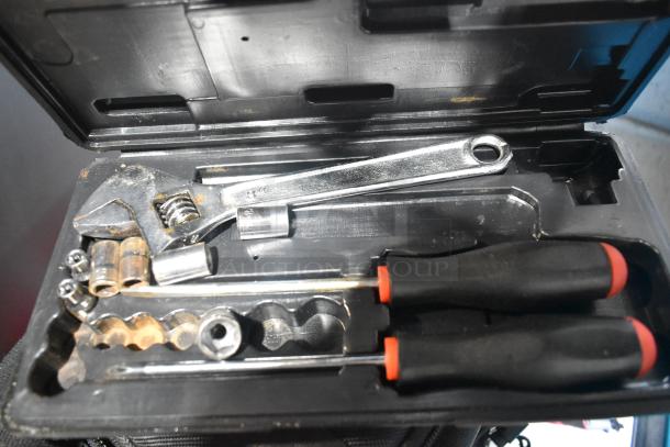 Tool set in black case, includes wrenches, screwdrivers, and sockets. Used condition with some rust visible.