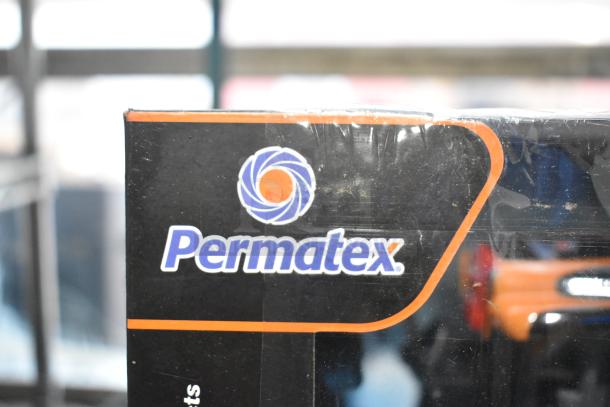 Permatex Gasket Maker packaging, black box with logo, part of auction lot including tools and accessories.