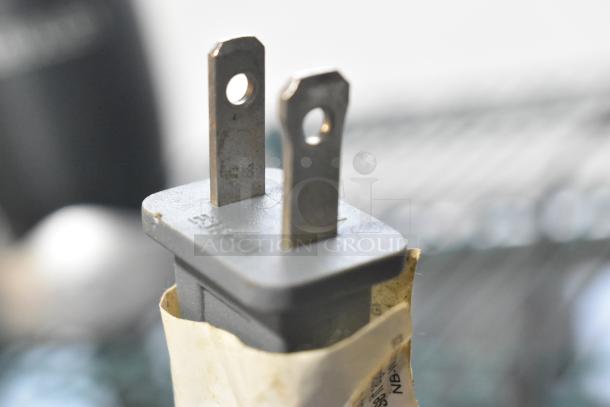 Close-up of Nutribullet blender plug, 115 volts, 1 phase, with visible label wrapped around the base.