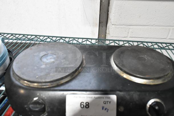 Two-burner electric range in used condition with visible wear, placed on a metal rack. Visible tag reads "68 QTY".