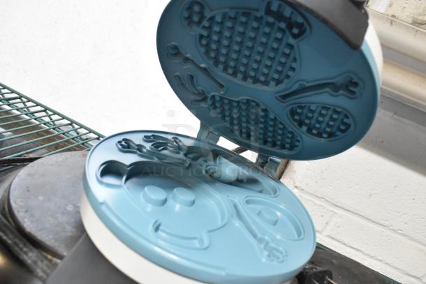 Olaf-themed waffle maker open, showcasing intricate mold design. Good condition, part of auction set with 2-burner range.