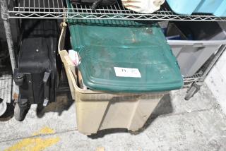 "Tier lot with luggage, multiple poly bins, DVDs, and PS4 on metal shelving. Item label reads '71 Qty Lot.'"