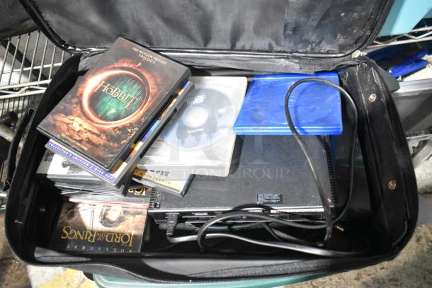 Tier lot featuring luggage with DVDs, including "The Hobbit" and "The Lord of the Rings," plus a PS4 in fair condition.