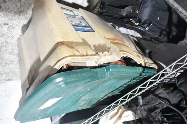 Various items including luggage, poly bins, DVDs, and PS4. Items in used condition with visible wear and labels.