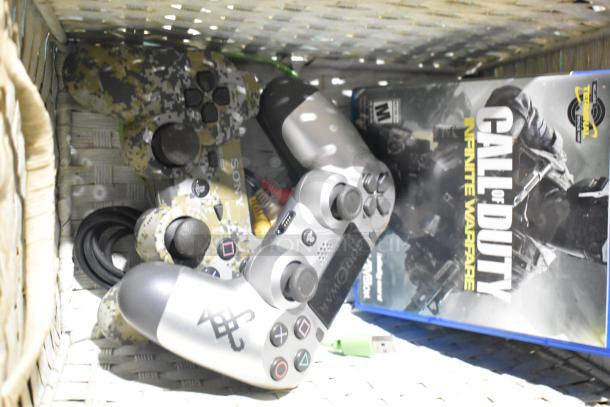 Sony PS4 controllers and "Call of Duty: Infinite Warfare" game in a wicker basket. Items appear in used condition.