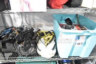 Lot of miscellaneous items including jumper cables, tools, and a rainsuit in good condition. Labels display "Sterilite" and "72".