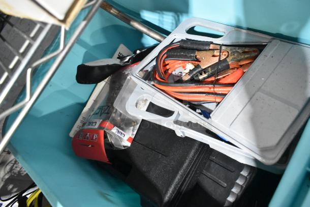 Tier lot with various items including jumper cables, hand tools, and a rainsuit in bin. Items appear in used condition.