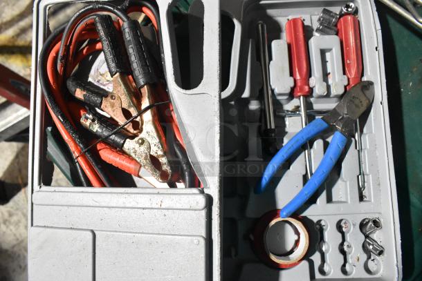 Box of various tools including jumper cables, screwdrivers, pliers, sockets, and tape, in used condition.
