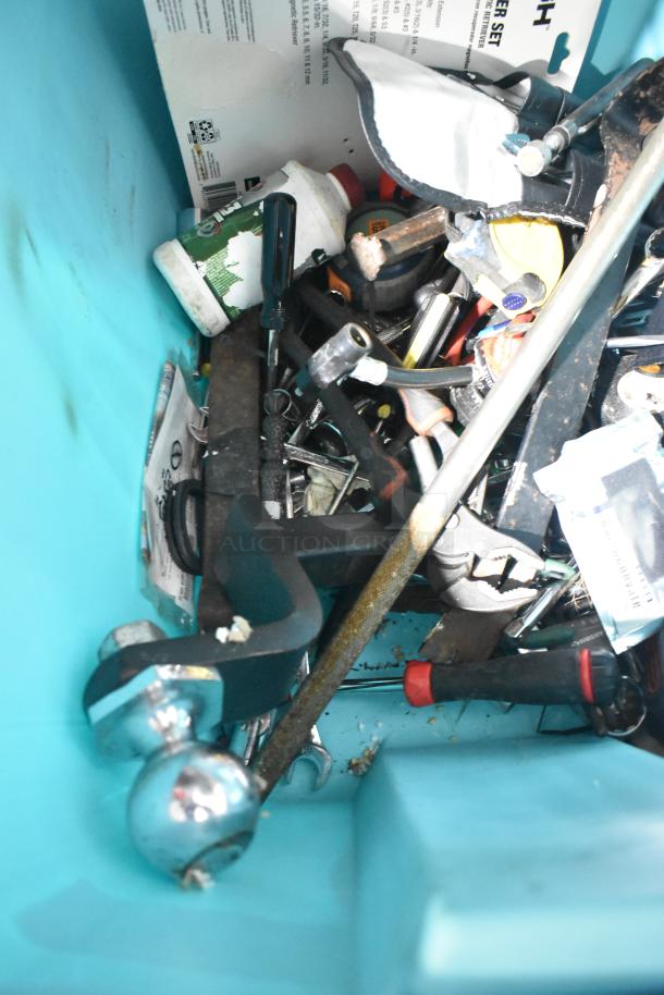 Assorted lot of tools in good condition, including jumper cables, wrenches, and a rainsuit, in a teal container.