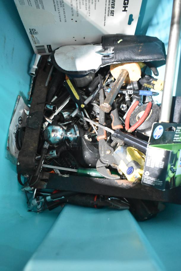 Various tools, jumper cables, and a rainsuit in a blue container; mixed condition.