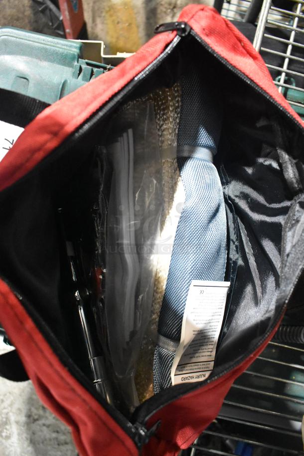 Red bag containing items including CDs, a unicorn tent, and a Westward power source. Bag is partially open, showing various contents.