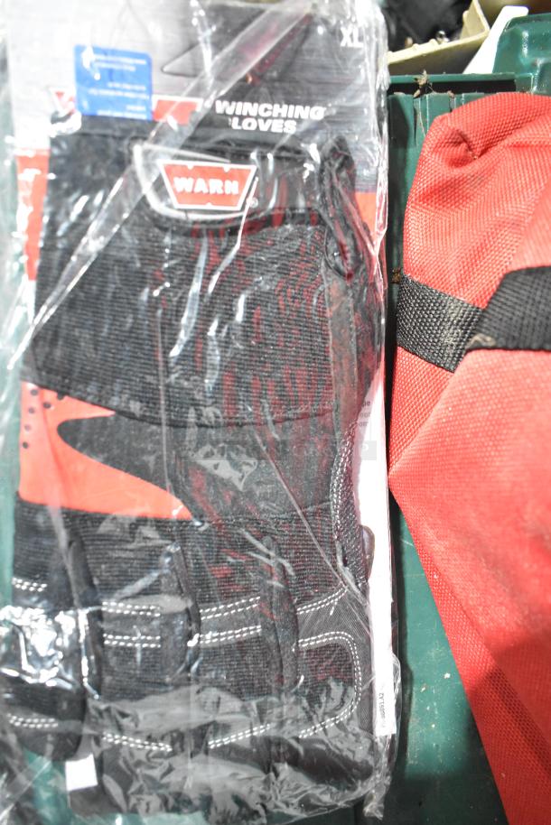 Tier lot featuring Warn winching gloves, new in packaging; red Jeep bag beside.