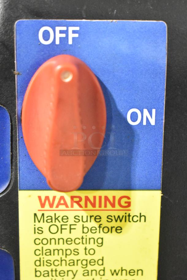 Red switch labeled "OFF/ON" with a warning sticker advising to keep it off before connecting clamps to a discharged battery.