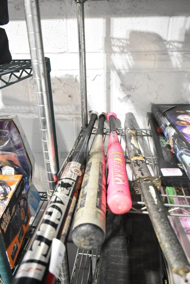 Tier lot of various items including assorted baseball bats, "Black Panther" poster, and lighthouse fixture on metal shelves.