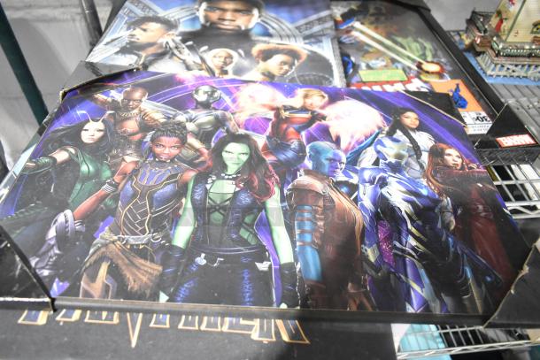 ALL ONE MONEY! Lot with various items including a colorful superhero poster, Black Panther theme, and additional collectibles in background.