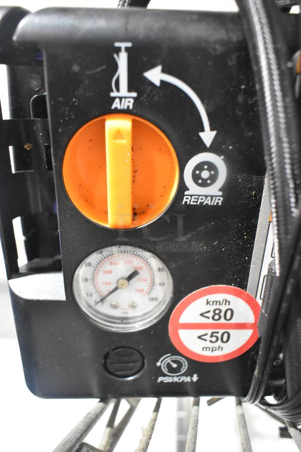 Close-up of a portable air pump with repair function. Features pressure gauge and dual units for PSI/KPA. Good condition.