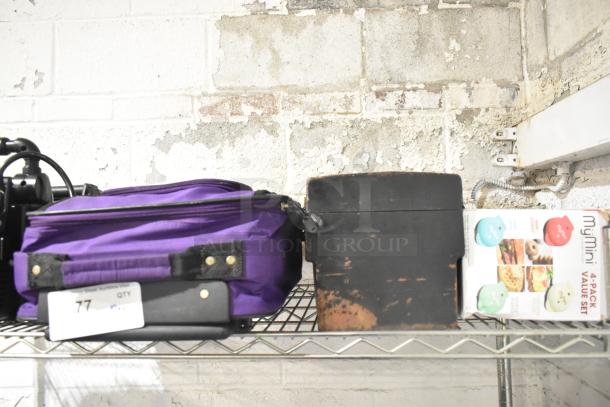 Lot of mixed items including purple luggage, black toolbox, and MyMini waffle maker set on wire shelf.