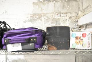 Lot of mixed items including purple luggage, black toolbox, and MyMini waffle maker set on wire shelf.