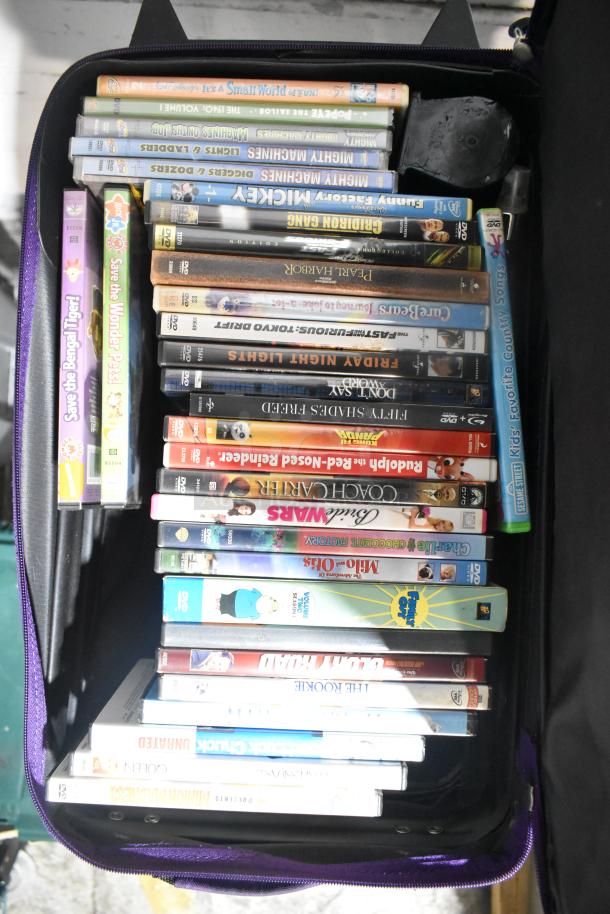 Lot of various items including an open suitcase filled with DVDs. Titles visible, condition varies. Great for collectors.