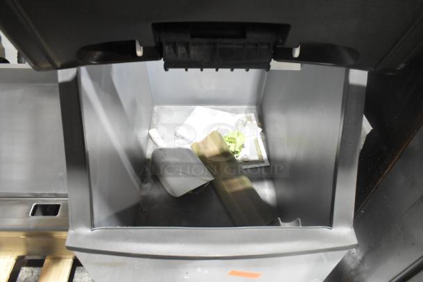 BRAND NEW SCRATCH AND DENT Manitowoc B320 stainless steel commercial ice bin, interior view, includes scoop and papers.